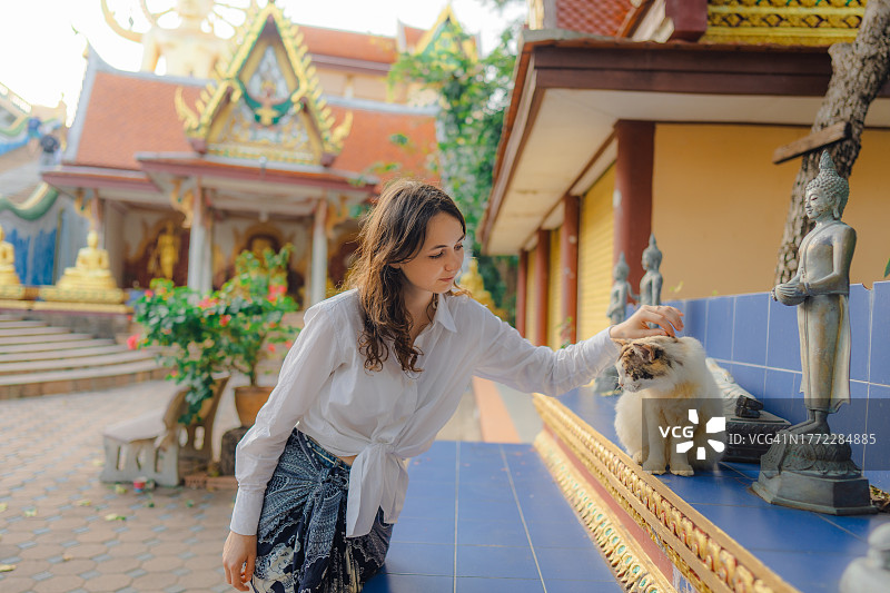 女人在寺庙里爱抚猫图片素材