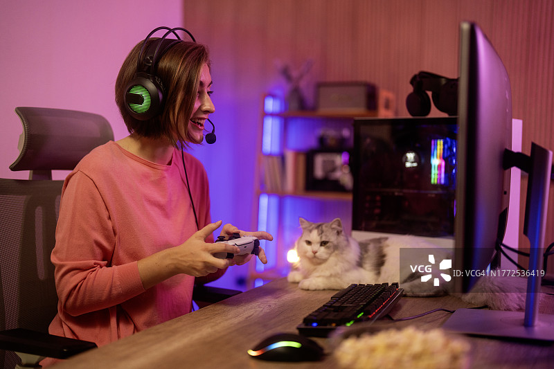 女人手持游戏控制器，戴耳机玩游戏图片素材