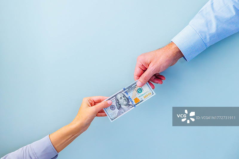两个人拿着一张百元美钞图片素材