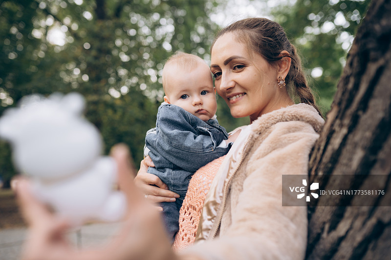 母亲用拨浪鼓逗宝宝开心图片素材