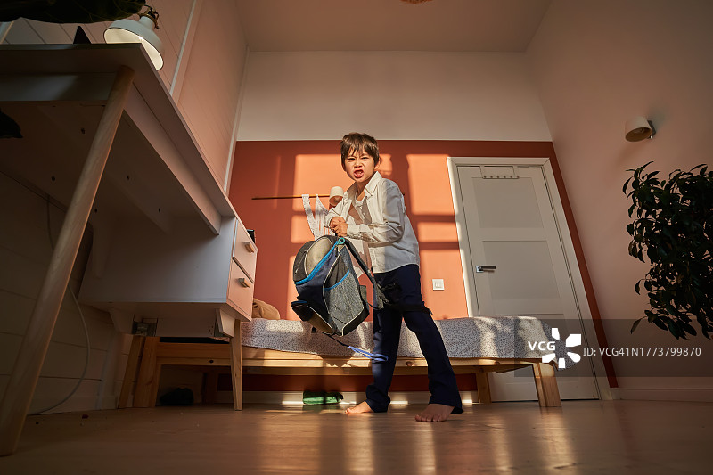 生气地甩背包的韩国男孩，学业上的失败图片素材