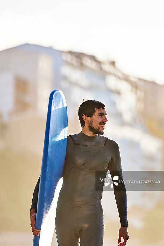 在城市环境中自信的冲浪者与滑板图片素材