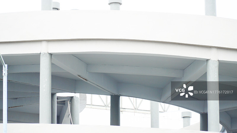 极简主义白色螺旋停车场建筑，带白色杆结构图片素材