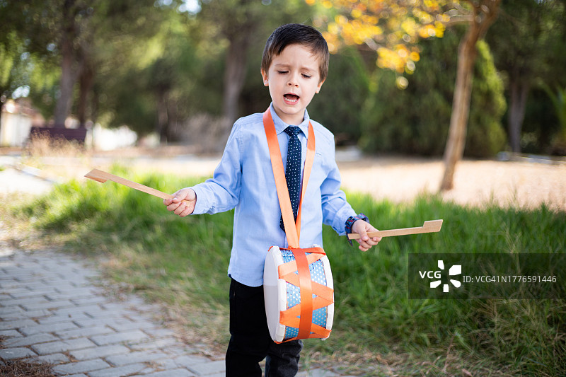 男孩在公园里吹喇叭图片素材