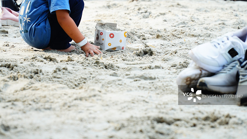 儿童在沙滩上玩沙子图片素材