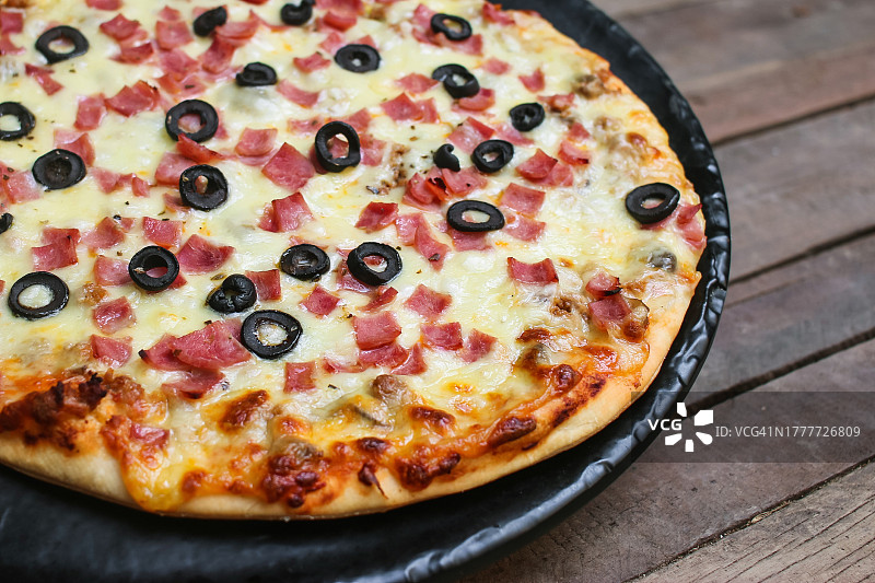 木桌上的火腿橄榄披萨图片素材