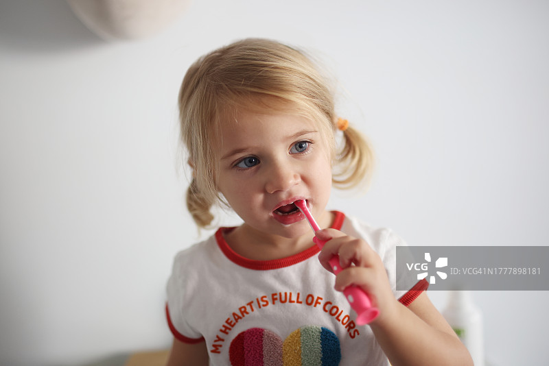 在浴室刷牙的3岁小女孩图片素材