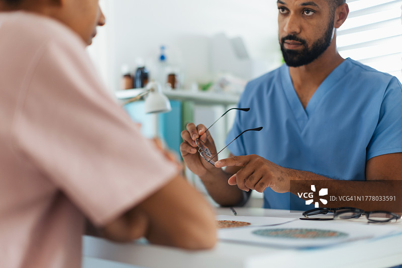 眼科医生向青少年患者解释处方眼镜的用途和眼部状况年度眼科检查图片素材