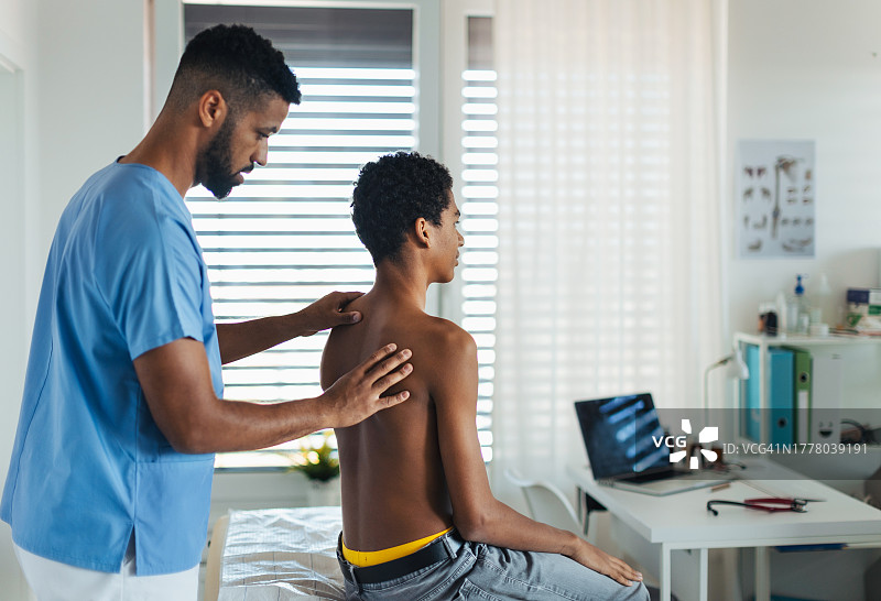 医生检查青少年脊柱侧弯和姿势，青少年接受儿科医生年度体检，青少年预防保健概念图片素材
