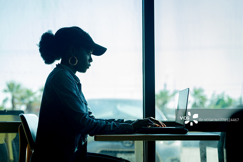 在美国德克萨斯州科珀斯克里斯蒂的办公室里使用笔记本电脑的女商人侧面图图片素材