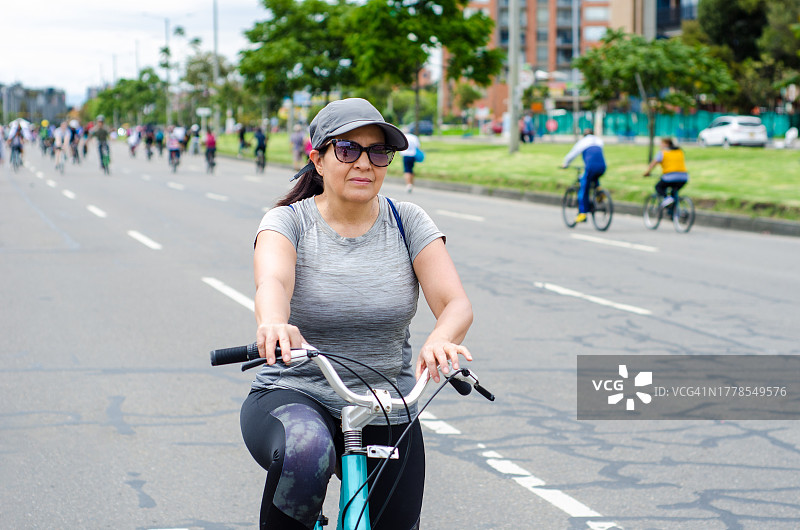 中年妇女在街上骑自行车图片素材