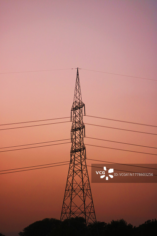 日落时分天空下的电塔低角度景象图片素材