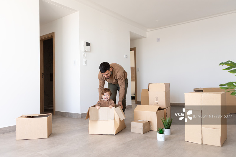 父亲和孩子们在新家拆箱玩耍图片素材