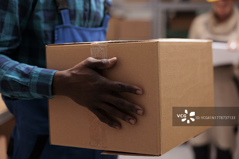 手捧纸箱的送货员（腰部特写）图片素材