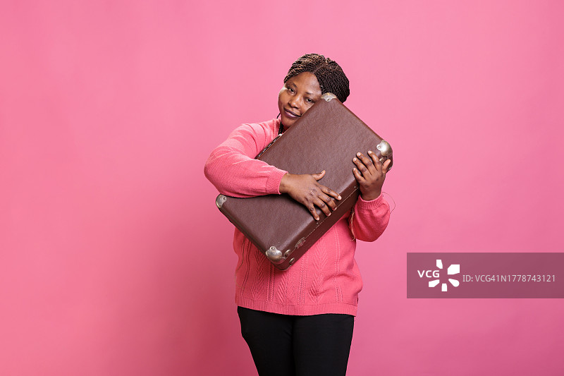 对着粉色背景微笑的黑人女性图片素材