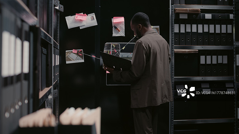 男侦探在档案室阅读证人陈述图片素材