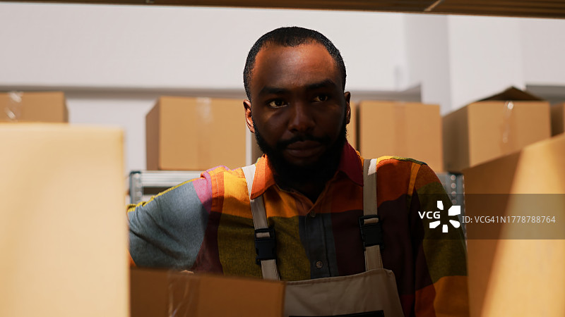 年轻男子在仓库整理箱子图片素材