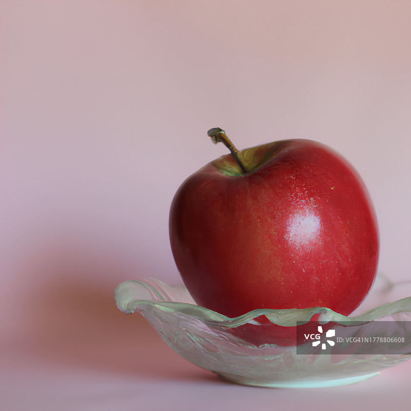 靠在粉色背景的水果碗上的苹果特写图片素材