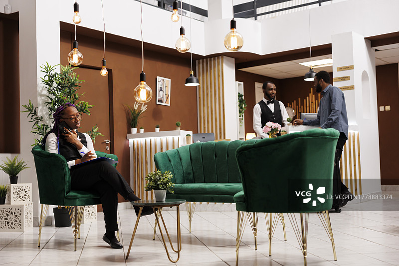 酒店经理坐在酒店大堂的沙发上讲手机图片素材