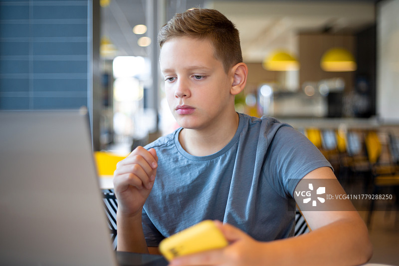 使用笔记本电脑上网课的青少年男孩图片素材