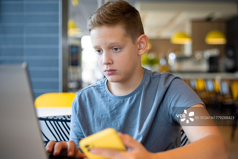使用笔记本电脑上网课的青少年男孩图片素材