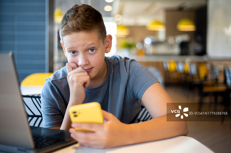 使用笔记本电脑上网课的青少年男孩图片素材