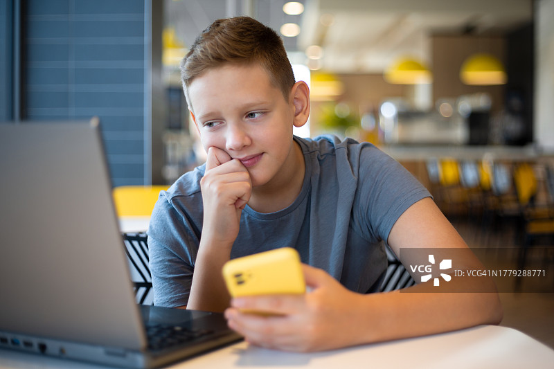 使用笔记本电脑上网课的青少年男孩图片素材