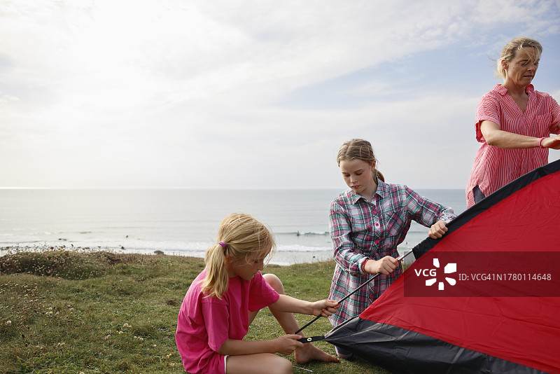 一家人在海边悬崖上搭建帐篷图片素材