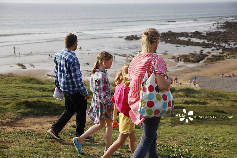 一家人沿着海岸小路走向海滩图片素材