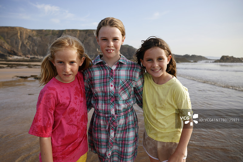 在海滩上一起玩耍的三个女孩的肖像图片素材
