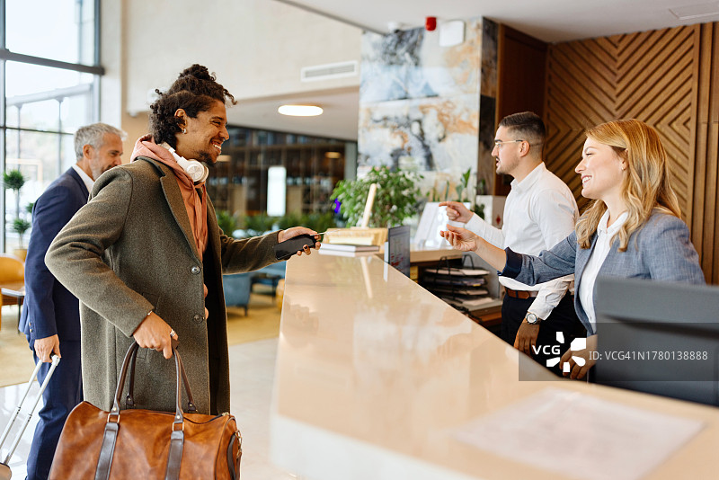 笑容满面的西班牙裔男人办理酒店入住图片素材