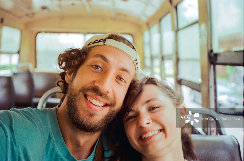 旅行中在当地巴士上的一对男女的自拍图片素材