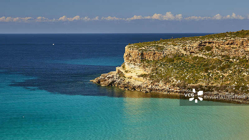 绿色的海、蓝色的海、悬崖、云层、蓝天——兔子岛，位于意大利西西里岛阿格里真托省兰佩杜萨岛图片素材