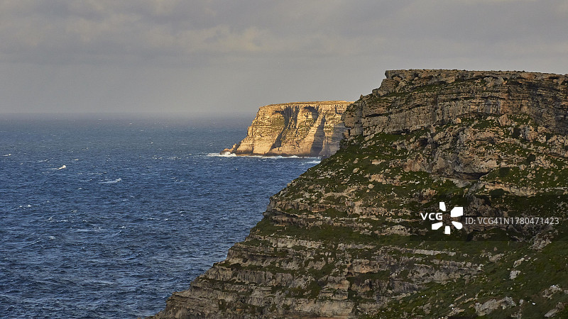 傍晚时分的悬崖，海浪，位于意大利西西里岛兰佩杜萨岛图片素材