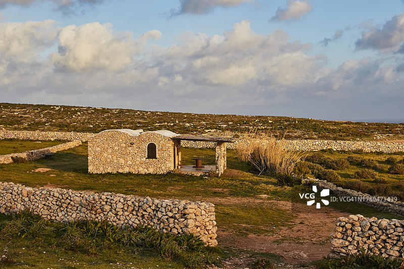 意大利西西里岛兰佩杜萨岛的傍晚景色：石头墙与荒凉的景观图片素材
