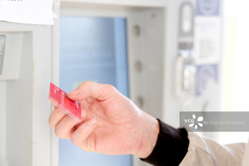 男子用红色信用卡支付停车费特写图片素材