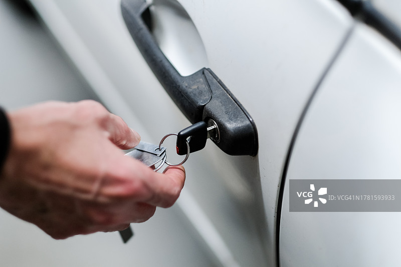 男人手中的车钥匙与车门特写图片素材