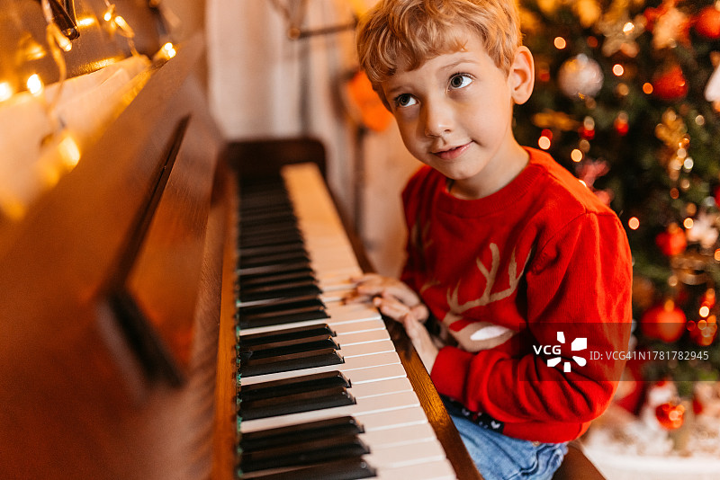圣诞节弹钢琴的小男孩图片素材