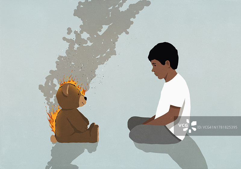 男孩看着燃烧的泰迪熊图片素材