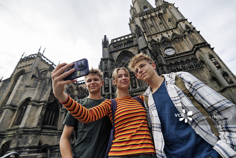 三个青少年在英国布里斯托尔的圣玛丽雷德克利夫教堂前自拍图片素材