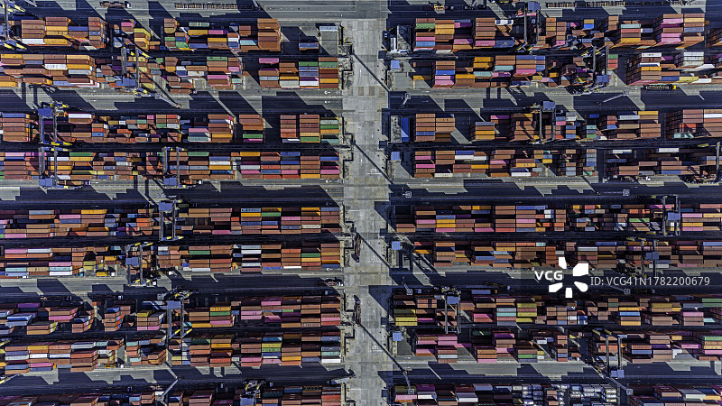 港口俯瞰图，集装箱船通过起重机装载图片素材