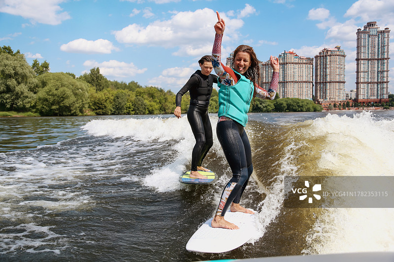 两位年轻漂亮的成年女性一起训练尾波滑水图片素材
