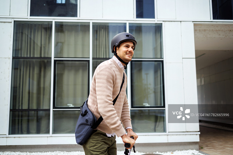 年轻帅气的男人骑着滑板车图片素材