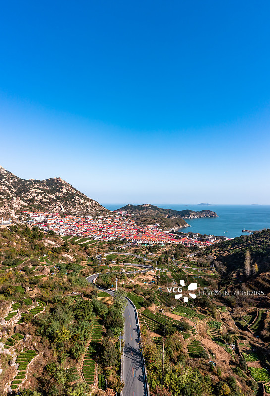 航拍：中国山东省青岛市崂山区青山渔村的红色瓦房屋图片素材