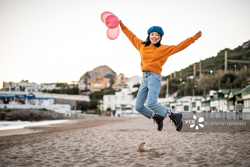 一位手里拿着气球的快乐的年轻中国女人图片素材