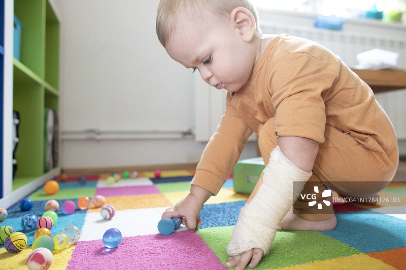 受伤的男婴在房间里玩耍图片素材