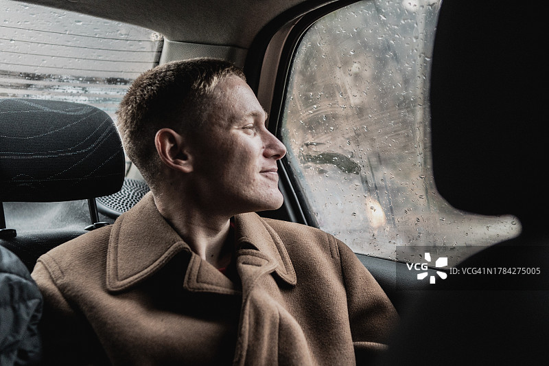 年轻男人看着出租车窗外图片素材
