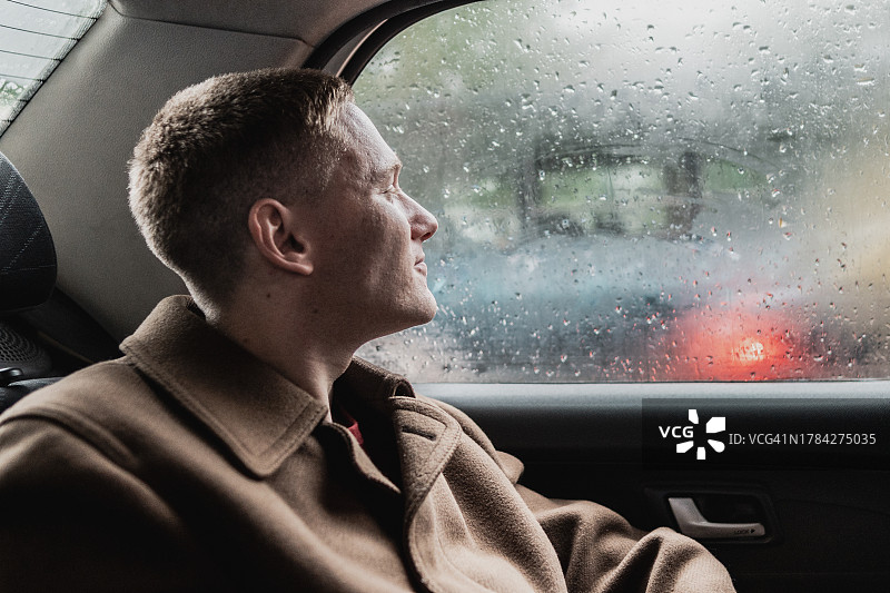 年轻男人看着出租车窗外图片素材