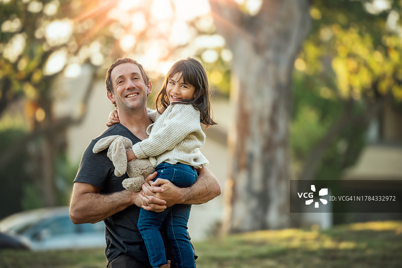 微笑的爸爸抱着微笑的4岁女儿图片素材