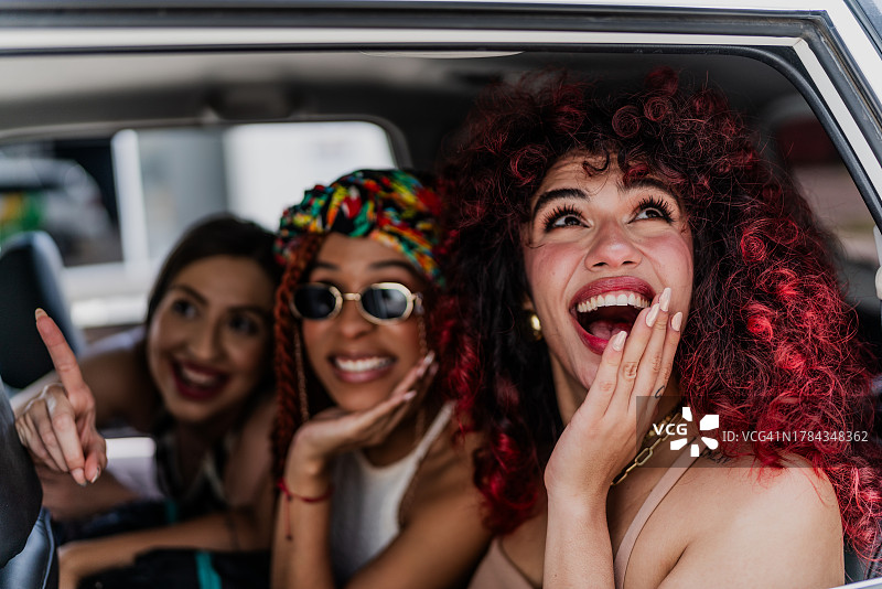 快乐的女性朋友在出租车里看风景图片素材